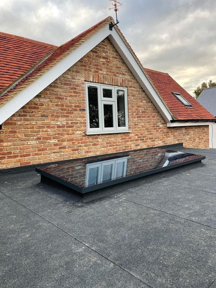 Flat roof with frameless glass skylight